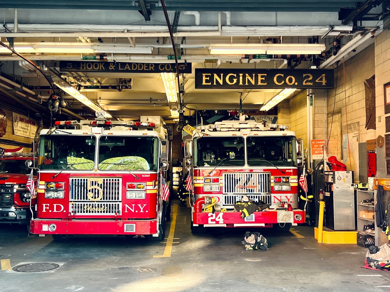 Two fire appliances standing in the bay of a fire station